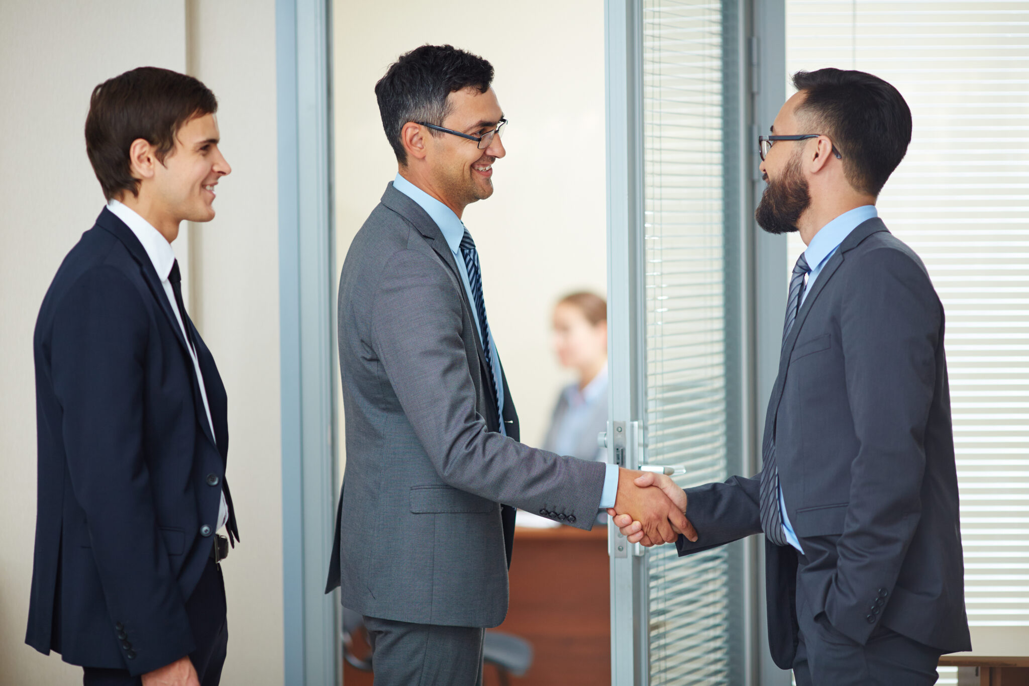 Two businessmen handshaking in office after signing contract